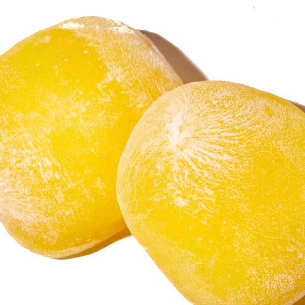 Two yellow Kubota Daifuku Mochi: Yuzu pieces with a powdery coating are displayed on a white background, showcasing this classic Japanese dessert from the 4 Pack.