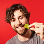 A smiling man with curly hair eats a piece of matcha Nestle Japan Rich Green Tea Free Gift against a red background. thumbnail 3