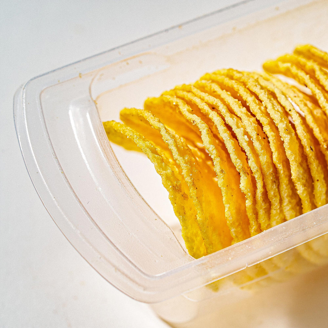 A clear package houses an organized stack of delicious, yellow, crispy Lay's Potato Chips: Braised Pork.