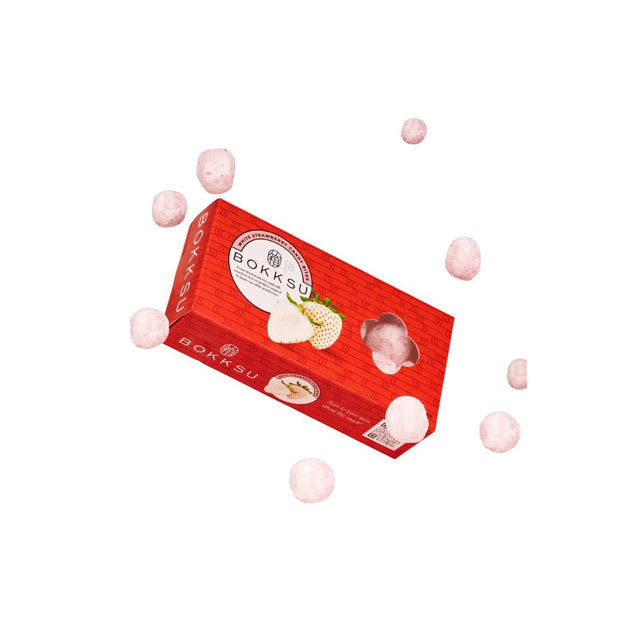 A Japan Crate Medium Crate filled with Japanese snacks, featuring strawberry treats and pink-coated snack balls, is displayed on a white background.