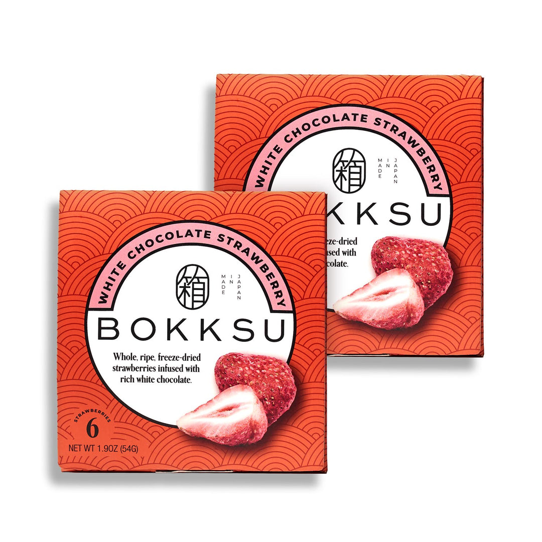 Two boxes of Bokksu's Bokksu White Strawberry 6-Piece Box (2-Pack), featuring images of freeze-dried strawberries coated in white chocolate on the packaging. Each box is 1.9 oz (54g) and showcases the artisanal Japanese snack experience.