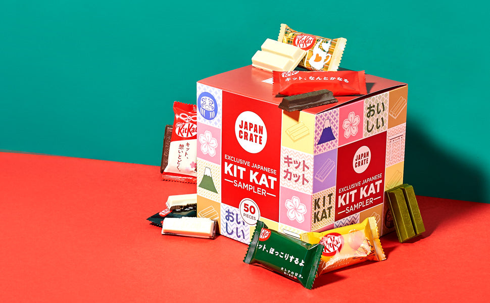 A Bokksu Market Kit Kat Sampler (50 pcs.) with a variety pack of Japanese Kit Kat flavors in colorful wrappers displayed around it against a green and red background.