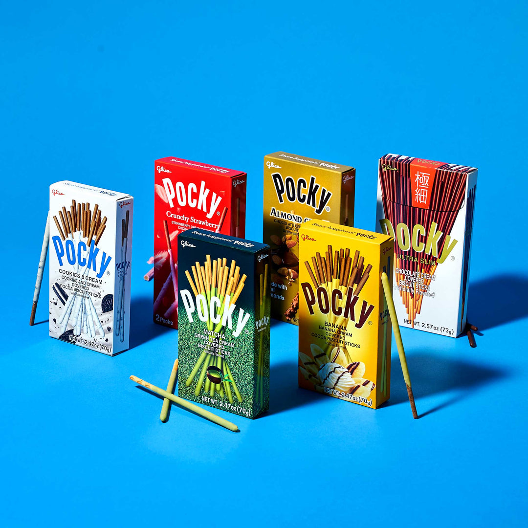 A Glico Pocky: Variety Pack, featuring an array of six snack boxes on a blue background, highlights different flavor options with biscuit sticks partially covered in delicious coatings.