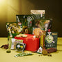 The Matcha Moments Box is displayed amidst a variety of matcha treats and Japanese green tea snacks in green packaging, set against a vivid green and gold backdrop. thumbnail 1