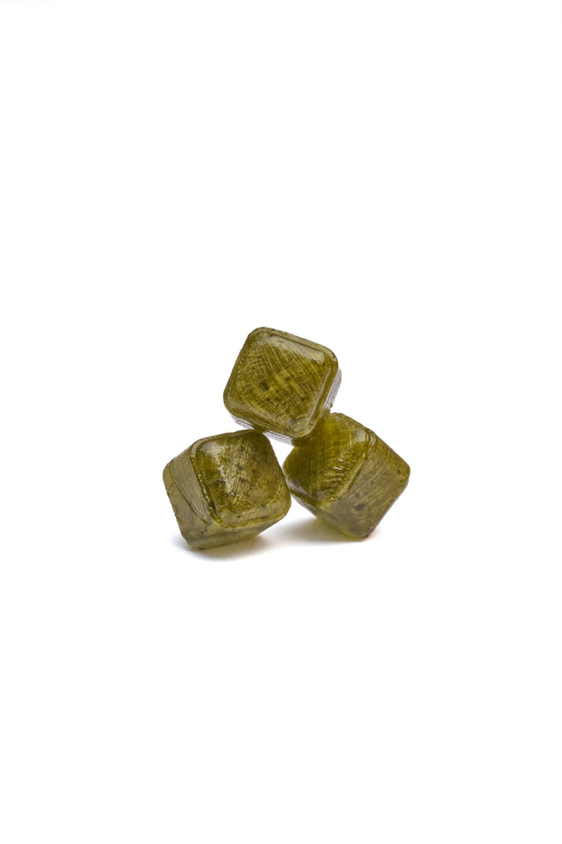 Three Bokksu Sweet Matcha Drops, greenish-brown hard candies, are stacked against a white background.