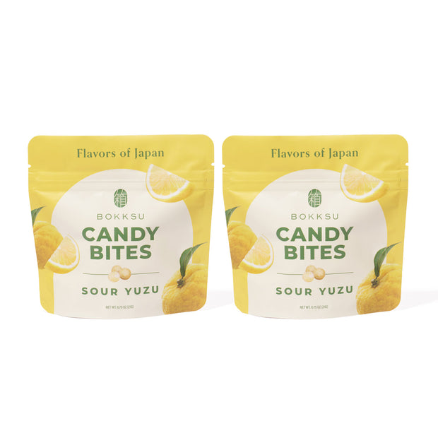 Two yellow and white pouches labeled "Sour Yuzu Japanese Candy Bites 0.75oz (2-Pack)" feature yuzu and lemon images, celebrating Japanese citrus flavors with "Flavors of Japan" on the packaging.