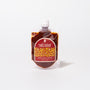 A pouch of Bokksu Fiery Garlic Chili Sauce, a Japanese chili garlic paste, with a white cap and red label featuring yellow accents, stands upright against a plain white background. thumbnail 1