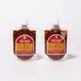 Two Bokksu Fiery Garlic Chili Sauce (2-Pack) pouches, featuring red labels and filled with dark spicy chili garlic paste, made in Japan, are shown side by side on a white background. thumbnail 1