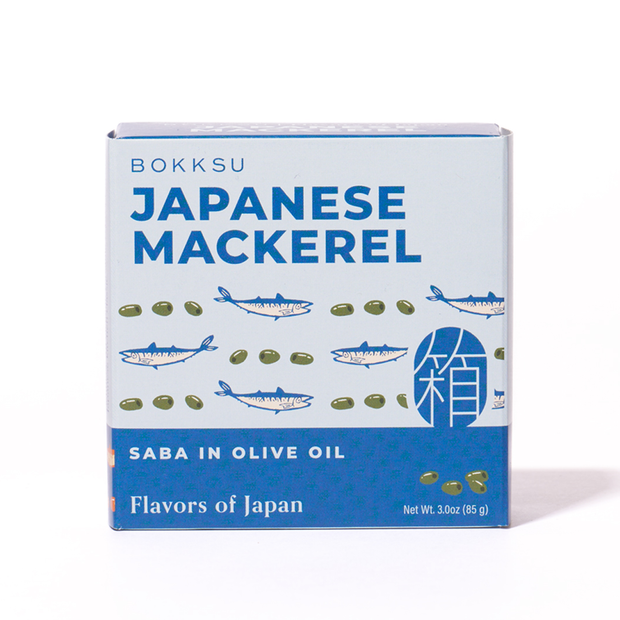 A box of Bokksu Japanese Mackerel labeled "Flavors of Japan" features illustrated fish and green olives. This delicacy is made in Japan and comes in olive oil. Net weight: 3.0 oz (85 g).