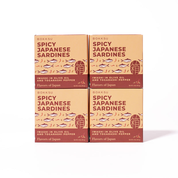 Four boxes of Bokksu Spicy Japanese Sardines (4-Pack) with iwashi in olive oil and togarashi pepper are displayed in a 2x2 grid on a white background.