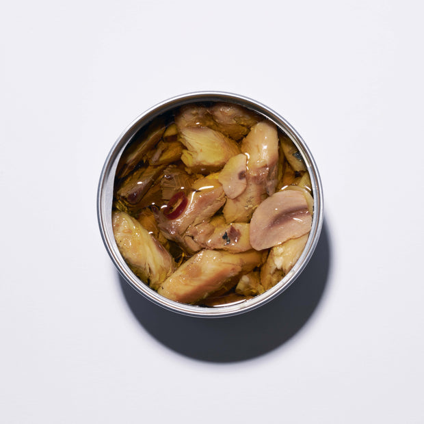 An open tin of Bokksu Spicy Japanese Sardines in olive oil, viewed from above on a plain white surface.