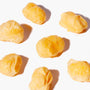 Several yellow cheese curds from the Doki Doki Snack Mix: Japan Mochi Puffs are arranged on a white background, casting small shadows. thumbnail 9