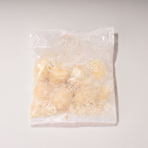 A clear plastic wrapper containing light brown, powdery Doki Doki Snack Mix: Japan Mochi Puffs is photographed on a plain white background.