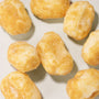 Several golden-brown breaded nuggets, resembling Japanese mochi snacks, from the Doki Doki Snack Mix: Japan Mochi Puffs, are arranged on a light surface. thumbnail 7