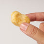 A hand holds a Doki Doki Snack Mix: Japan Mochi Puffs, a small sugar-coated Japanese mochi snack, against a plain white background. thumbnail 8