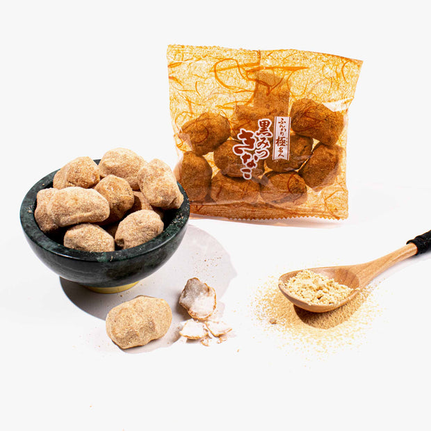A bowl of Doki Doki Snack Mix: Japan Mochi Puffs, a wooden spoon with powder, a broken mochi candy, and a yellow package of the same snacks are displayed on a white background.