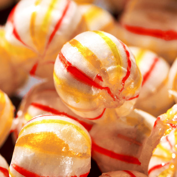 Close-up of Daimonji Ame Honpo Handmade Candy Gift Box (12 Bags, 6 Flavors)—round hard candies with shiny yellow and red stripes.