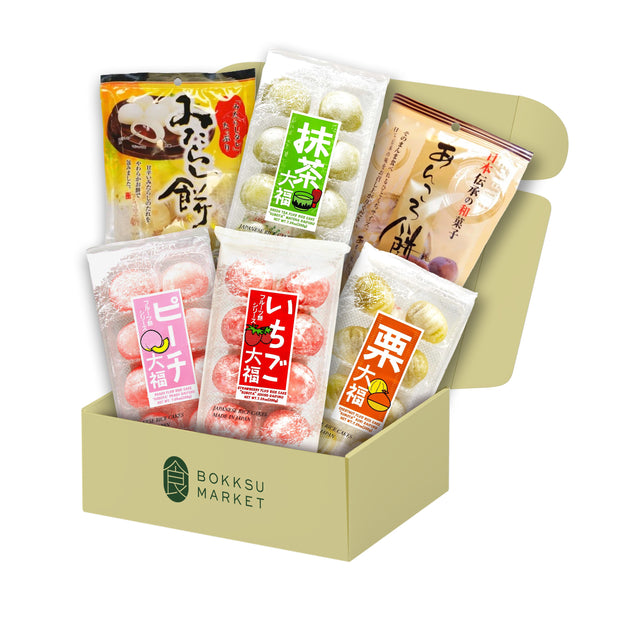 An open Bokksu Market Mochi Bundle box containing assorted packaged Japanese snacks, featuring mochi and daifuku in flavors like matcha, strawberry, and peach.