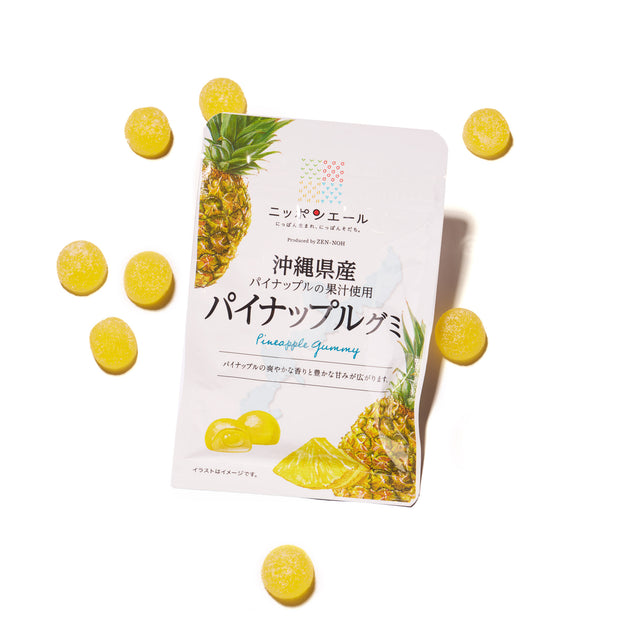 A Premium Japanese Fresh Gummy Box (Orange Box) is displayed on a white background, surrounded by several yellow round gummies. The packaging features images of pineapples and Japanese text.