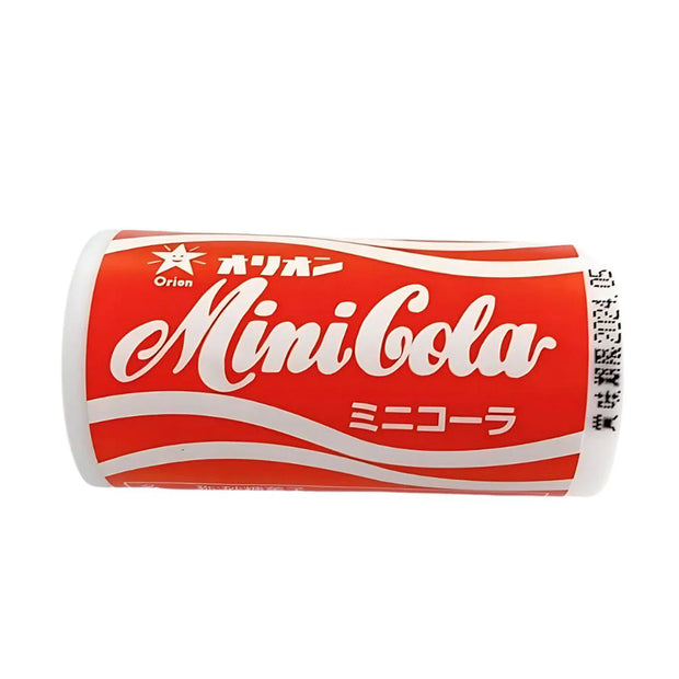A small red can labeled "Mini Cola" with white script and Japanese text, featuring a barcode on the side—this iconic Japanese candy is a popular treat often included in the Dagashi Snack Crate, a 30-piece variety box featuring classic Japanese snacks like candy, chocolate, cookies, mochi, and Ramune treats.