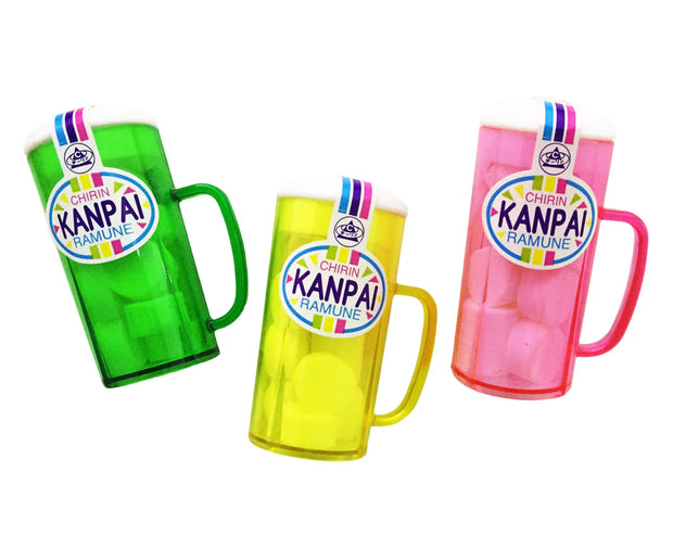 Three plastic mugs in green, yellow, and pink with white foam tops and “Kanpai Ramune” labels are displayed against a white background—an ideal choice for fans of Japanese treats or a fun complement to the Dagashi Snack Crate 30-Piece Japanese Snack Variety Box featuring candy, chocolate, cookies, mochi, and Ramune treats.