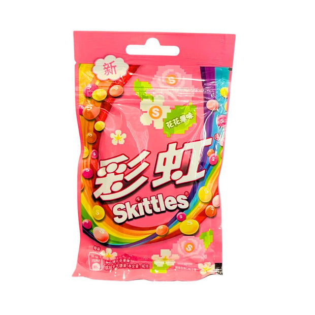 A pink bag of Skittles Candy: Floral Fruit with colorful branding, Chinese text, a rainbow, and assorted pieces on the packaging highlights its chewy floral fruit flavor.