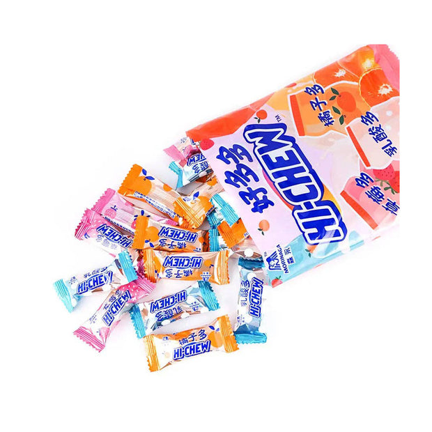 An opened bag of Morinaga Hi-Chew: Mixed Soft Candy with colorful, individually wrapped pieces scattered on a white surface.