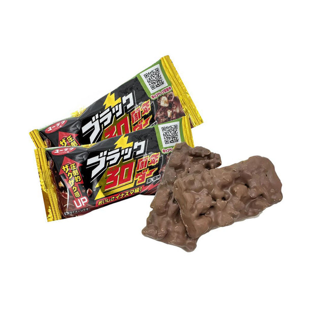 Two packaged Yuraku Seika Black Thunder chocolate bars and two unwrapped, irregularly shaped cocoa cookies are displayed on a white background.