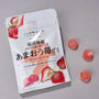 A Japanese Fruits Gummy Box featuring authentic Amaou strawberry flavor, with vibrant strawberry images and four round pink gummies displayed on a gray surface. thumbnail 3