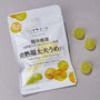 A white "Tsudakyo Lime Gummy" packet with grape illustrations sits next to four yellow-green gummies, featured in the Japanese Fruits Gummy Box—a tempting pick for fans of authentic Japanese candy on a gray background. thumbnail 6