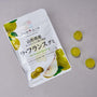 A white box labeled Japanese Fruits Gummy Box, featuring La France pear flavor, sits on a gray surface with three round yellow-green gummies displayed to its right. thumbnail 9