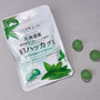 A Japanese Fruits Gummy Box sits beside three round green gummies on a gray surface, highlighting authentic Japanese flavors. thumbnail 11