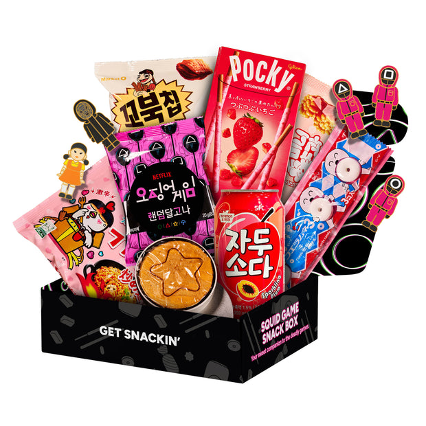 A black box with colorful graphics, featuring Squid Game symbols and characters, labeled “7 Snacks” and “Squid Game Season 3 x Japan Crate (Medium).”.