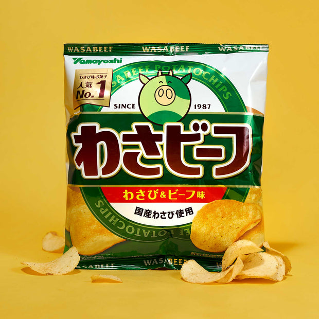 A bag of Yamayoshi Wasabeef potato chips, flavored with wasabi and beef, from the Bokksu Japanese Savory Snack Box, shown in green and yellow packaging with Japanese text on a yellow background alongside loose chips.