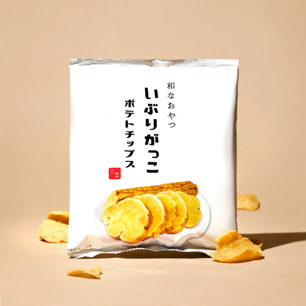 A white bag from The Japanese Savory Snack Box features sliced chips on the front, with scattered chips on a beige background—ideal for fans of Japanese savory snacks.