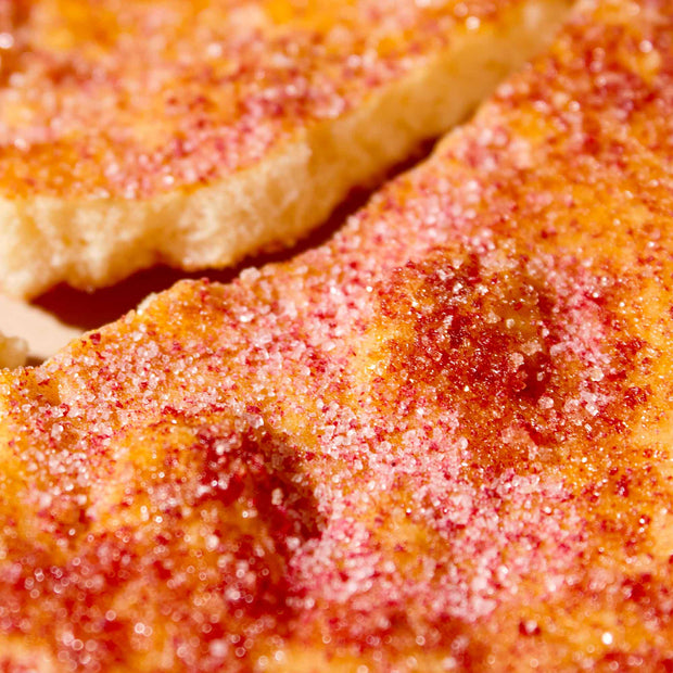 Close-up of toasted bread slices with butter, cinnamon, and sugar crystals—evoking the sweet flavors often included in The Japanese Savory Snack Box by Bokksu alongside traditional treats like senbei.