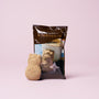 A cat-shaped brown sugar candy from The Cat Lover’s Box stands in front of a package featuring a cup of tea with Japanese text, set against a light pink background—making it the perfect treat for fans of cat-themed snacks and unique Japanese cat gifts. thumbnail 13