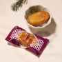 A Bokksu Snack Box: Seasons of Japan pastry sits packaged beside an unwrapped treat in a ceramic bowl with greenery, offering a tempting preview of authentic Japanese flavors on a light surface. thumbnail 11