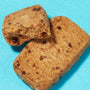 Two rectangular chocolate chip cookies on a blue background, one partially broken to reveal their crumbly texture—ideal for adding to your Bokksu Snack Box: Seasons of Japan and savoring alongside other unique Japanese treats. thumbnail 19