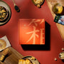 A Bokksu Snack Box: Seasons of Japan, surrounded by a tempting variety of Japanese snacks and a warm cup of tea on a vibrant red surface, captures the essence of Japan& thumbnail 2