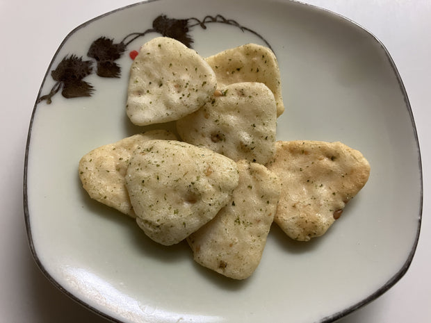 The Fiery Flavor Crate (Medium) is a green bag with rice crackers in nori wasabi flavor, ideal for spicy snack lovers, and shows images of the crackers and seaweed on the front.