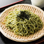 A bowl of Hakubaku Organic Cha Soba Green Tea Noodles on a table next to a cup of green tea. thumbnail 4